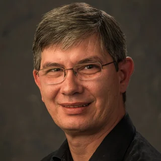 Photograph of Sherief Farid: a smiling man with short greying hair and rimless glasses, in a dark shirt.